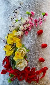 Bright Easter silver background decorated with ribbons of flowers and red e.. Stock Photos