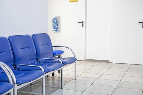 A bright, empty interior with blue waiting chairs in a medical facility Stock Photos