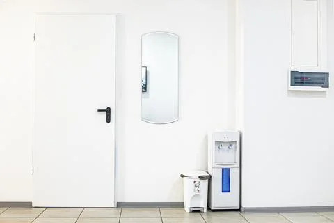 A bright empty interior with a water dispenser in a public place Stock Photos