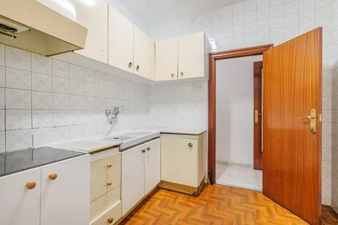 Bright empty kitchen with tiled floor and walls before renovation. Old typical 스톡 사진