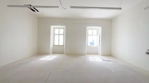 A bright, empty, spacious room in which renovations are being made. There are Stock Footage 295544009