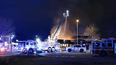 Bright establishing shot of massive fire caused by incendiary event Stock Footage 129987814