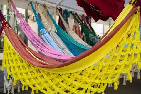 Bright ethnic hammocks with various pattern hanging in street market. Stock Photos