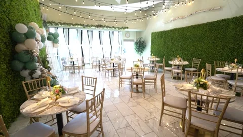 Bright event hall with gold chairs, hedge walls and balloons Stock Footage 345554150