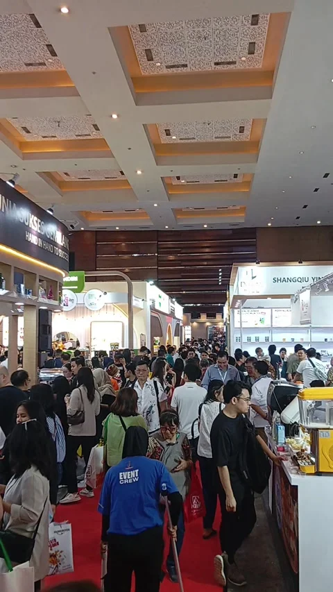 A bright exhibition hall filled with a crowd of shoppers and vendors Stock Footage 341388989