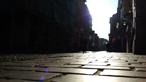 Bright falling sun rays on the cobblestone street Stock Footage 93644565