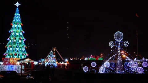 Bright festive night lights shine on Christmas market decorations on winter Stock Footage