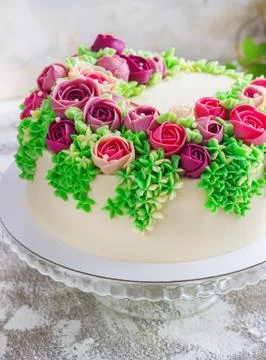 Bright festive white cake with bright flowers made of cream, a wedding cake, Stock Photos
