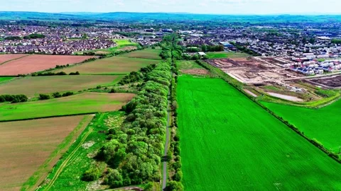 Bright fields of green patch the rural scene, where the town lines convene Stock Footage 337207477