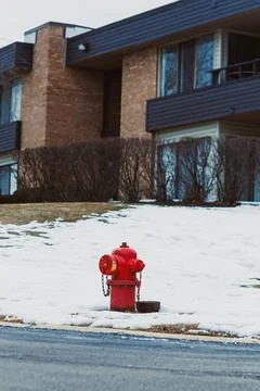 A bright fire hydrant is visible on the snow-covered ground next to a sidewal Foto stock
