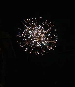 Bright firework explosion in night sky with golden light trails Stock Photos