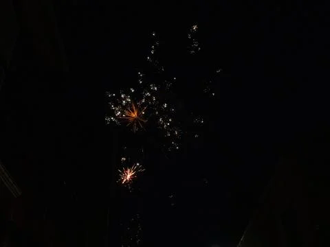 Bright firework explosion in night sky with golden light trails Stock Photos