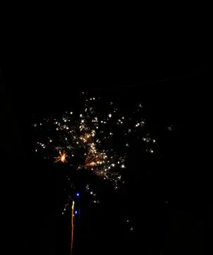 Bright firework explosion in night sky with golden light trails Stock Photos
