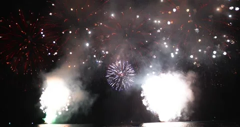 Bright fireworks explode across the night sky during a festive celebration. 库存影片 342298582