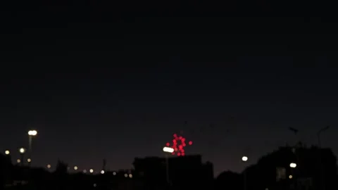 Bright fireworks explode in multiple colors against the dark night sky above a Video stock 346724897