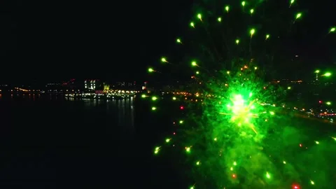 Bright fireworks exploding in the air on a background of the river and night Stock Footage 133675515