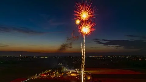 Bright Fireworks Exploding In The Evening Sky, Illuminating The Twilight Ho.. Foto stock
