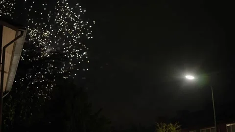 Bright Fireworks Exploding in the Night Sky Over a Residential Neighborhood Video stock 301742088