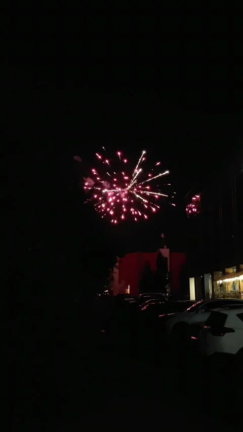 Bright fireworks explosion in the dark night sky over parking. Stock Footage 343672390