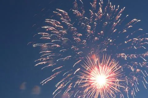 Bright fireworks explosion with a glowing core in the evening sky Stock Photos