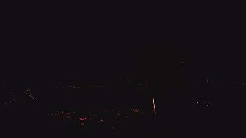 Bright fireworks light up the night sky over the city. People gather to watch Stock Footage 340405360
