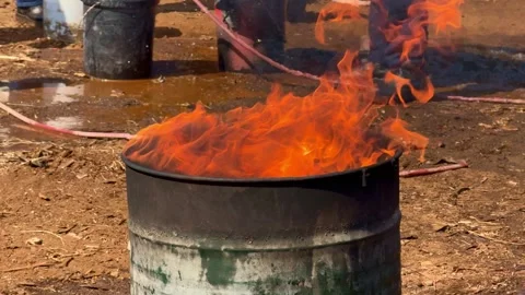 Bright flames burning inside metal drum during fire safety training. Video stock 341379822