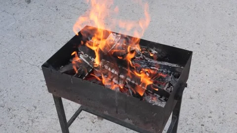 Bright flames burst from a grill in the backyard. Stock-Footage 288761654