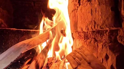 Bright flames flickering over burning logs in brick fireplace Video stock 320812680
