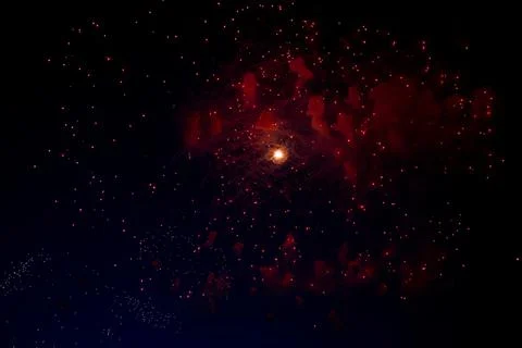 A bright flash in the center from the fireworks beginning to bloom and red Stock Photos