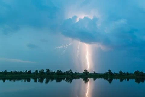 Bright flash of lightning over the river Stock Photos