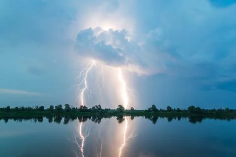 Bright flash of lightning over the river Stock Photos