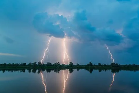 Bright flash of lightning over the river Stock Photos