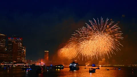 Bright flashes of fireworks light the waterscape and buildings facades of New Stock Footage 316555145
