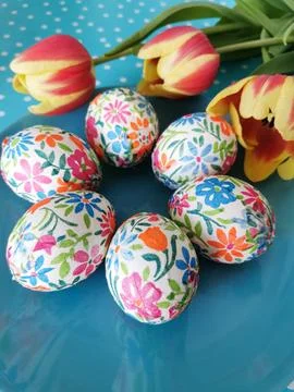 Bright floral printed Easter eggs with orange tulips on turquoise background. 写真素材