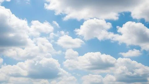 Bright fluffy white clouds floating in a clear blue sky on a sunny day Fotos de archivo