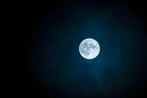 Bright Full Moon Centered in Cloudy Dark Blue Night Sky Stock Photos