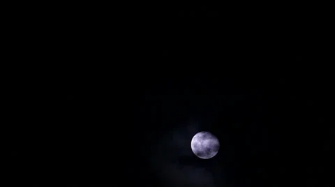 Bright full moon in darkness with clouds passing in front Video stock 36417254