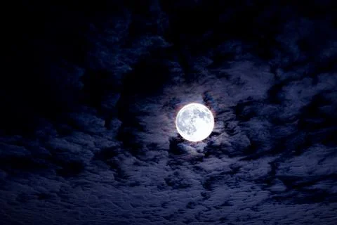 Bright full moon with dramatic night clouds. Moonlight on dark cloudy sky. Full Stock Photos