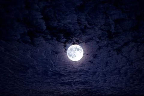 Bright full moon with dramatic night clouds. Moonlight on dark cloudy sky. .. Stock Photos