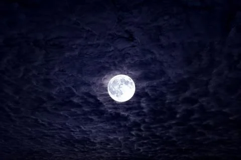 Bright full moon with dramatic night clouds. Moonlight on dark cloudy sky. .. Stock Photos