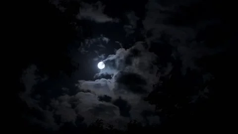 A bright, full moon in the night sky floats through the clouds. A terrible pi Stock Footage 159357370