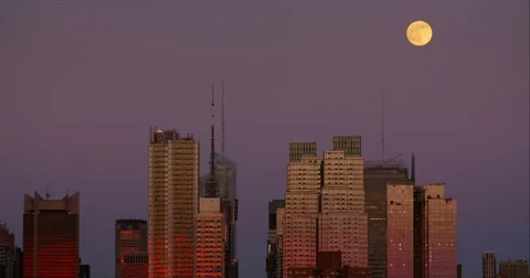 Bright full moon rises above skyscrapers in New York City Stock Footage 67289194
