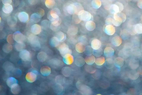 Bright glitter background: bokeh effect from many colored lights on frozen gl Stock Photos