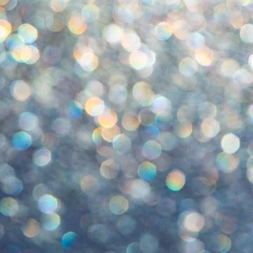 Bright glitter background: bokeh effect from many colored lights on frozen gl Stock Photos