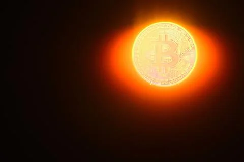 Bright glowing bitcoin instead a sun with and rays on black Foto stock