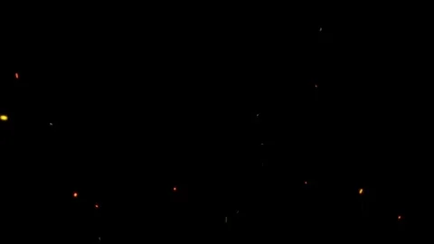 Bright glowing fire particles rising up and moving with the wind in a fiery Stock Footage 315161382