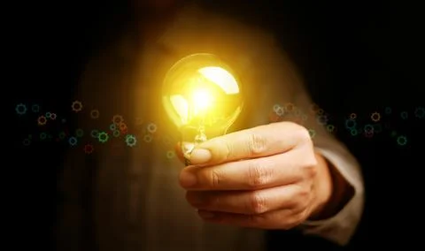 Bright glowing light bulb in hand symbolizing creativity, innovation, and n.. 写真素材