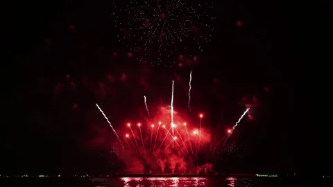 Bright golden fireworks exploding in the night sky over a dark horizon with Stockbeeldmateriaal 345852843