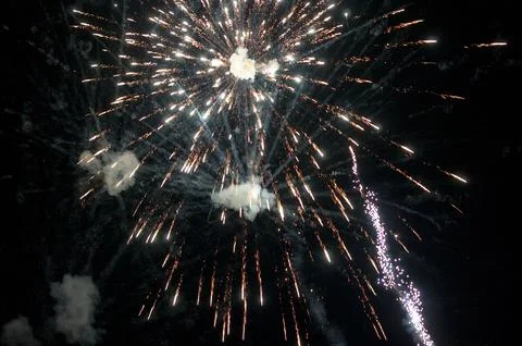 Bright golden fireworks exploding in the night sky Stock Photos