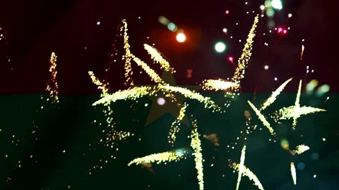 Bright golden fireworks exploding over the national flag of burkina faso du.. Video stock 343690943